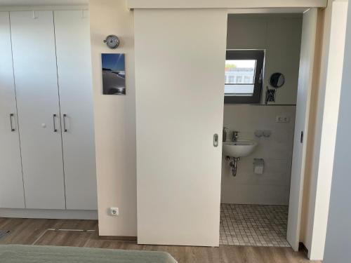 an open door in a bathroom with a sink at Hausboot Paula mit Reisekajak in Ribnitz-Damgarten in Ribnitz-Damgarten