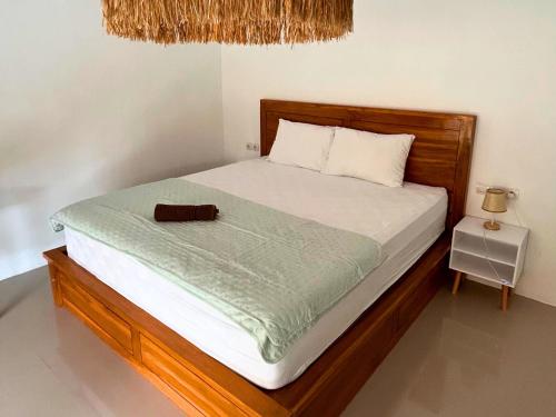 a bed with a wooden headboard and a night stand at The middle Surf house in Airsatang