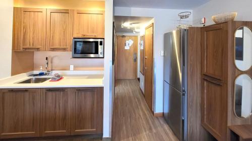 a kitchen with wooden cabinets and a stainless steel refrigerator at Cahilty #316 home in Sun Peaks