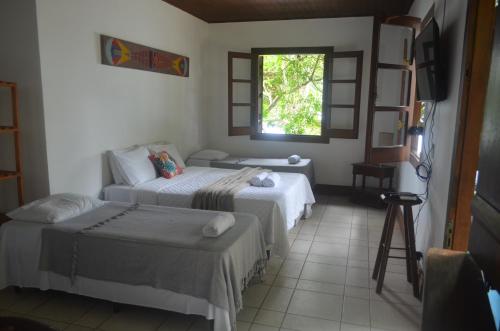 a room with two beds and a window at Deck Picinguaba Pousada in Picinguaba