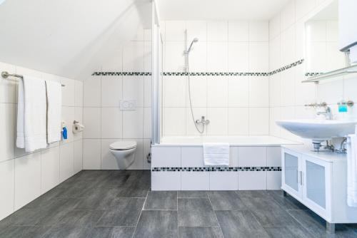 a white bathroom with a sink and a toilet at Ferienwohnungen Ammerwinkel in Oberammergau