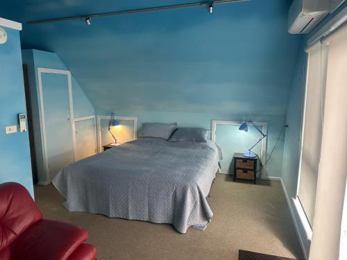 a blue bedroom with a bed and a blue wall at Blue Monkey Mountains in Newnes Junction