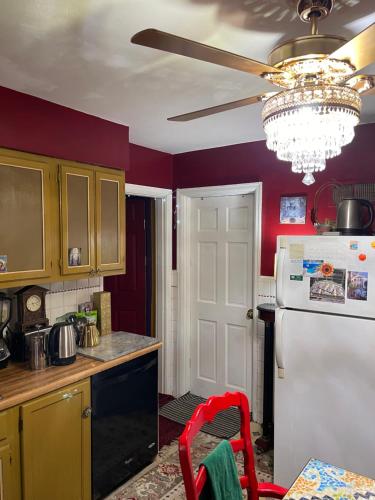 a kitchen with a white refrigerator and a ceiling fan at Cozy room in house at Airport & Highway in Saint Louis