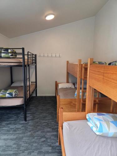 a dorm room with three bunk beds in it at Tasman Holiday Parks - Coromandel in Coromandel Town