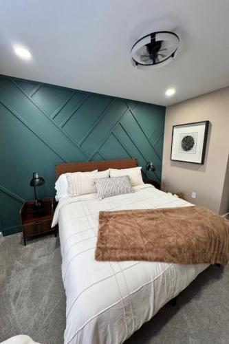 a bedroom with a large bed with a green wall at The Blue Venue-Periwinkle in Clarksville