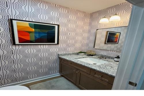 a bathroom with a sink and a painting on the wall at The Blue Venue-Periwinkle in Clarksville