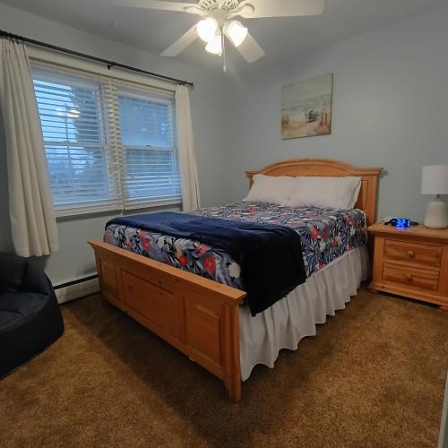 a bedroom with a bed and a ceiling fan at Cliffside Cottage in Mansfield