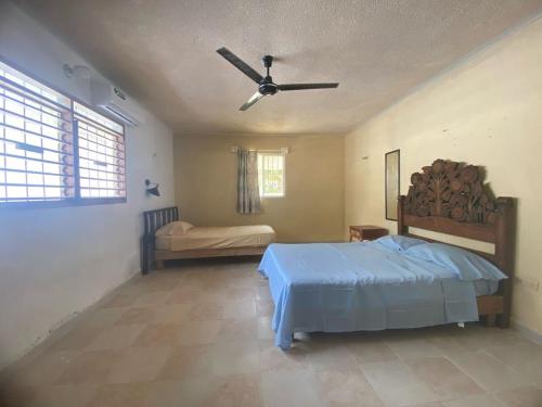 a bedroom with a bed and a ceiling fan at House 30 meters from the sea in Chicxulub