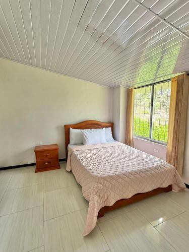 a bedroom with a bed and a large window at Casa Sué Soatá in Soatá