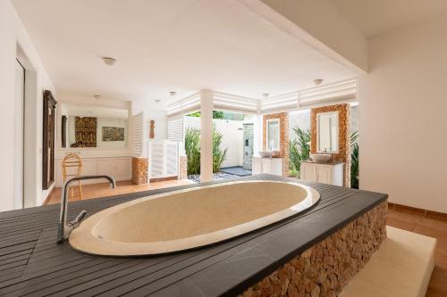 ein großes Badezimmer mit einer großen Badewanne in einem Zimmer in der Unterkunft Puri Mas Boutique Resort & Spa in Senggigi 