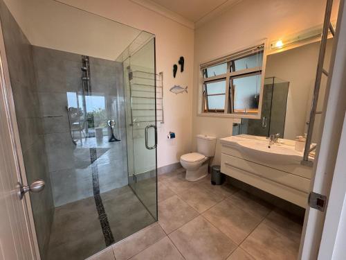 a bathroom with a shower and a toilet and a sink at Taipa Coastal Retreat in Taipa