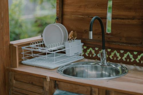 a kitchen sink with a dish drying rack next to it at Green vanilla mincung 1 in Silebeng