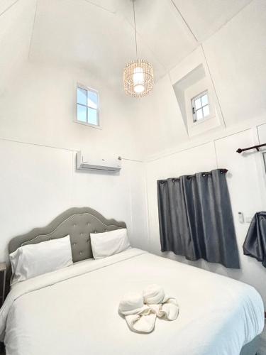 a bedroom with a bed with two white shoes on it at บ้านวิรา ห้องพัก Baan Wira in Khon Kaen