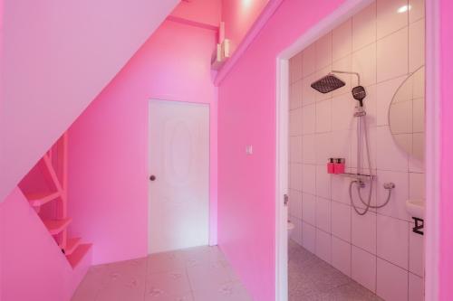 a bathroom with a pink wall and a toilet at บ้านพวงชมพูเกาะล้าน in Ko Larn