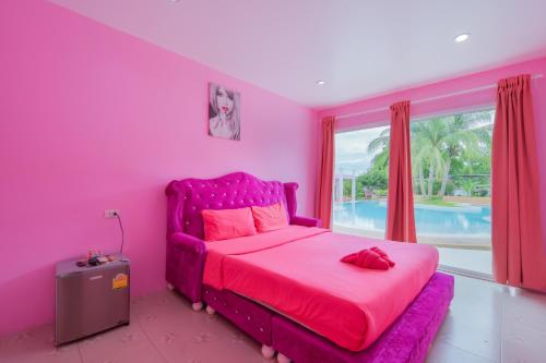 a pink bedroom with a pink bed and a window at บ้านพวงชมพูเกาะล้าน in Ko Larn