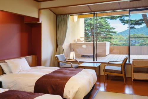 a hotel room with two beds and a view of a balcony at Jodogahama Park Hotel in Miyako