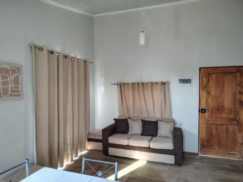 a living room with a couch in a room with curtains at Maravillas de Tongoy in Tongoy