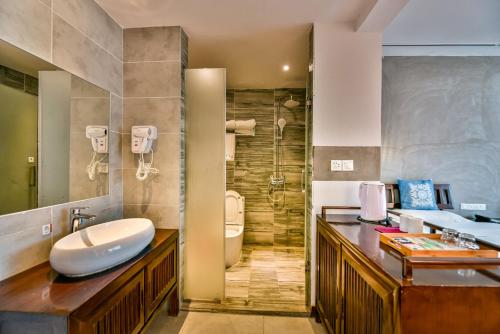 a bathroom with a sink and a toilet and a shower at Morning Sun Hotel in Yangshuo