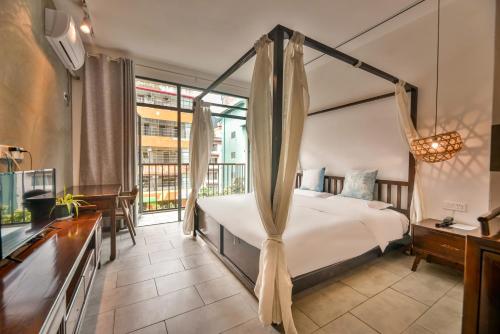 a bedroom with a bed and a large window at Morning Sun Hotel in Yangshuo