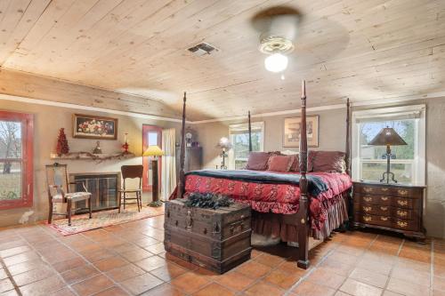 a bedroom with a canopy bed and a fireplace at Guadalupe Getaway in Kerrville