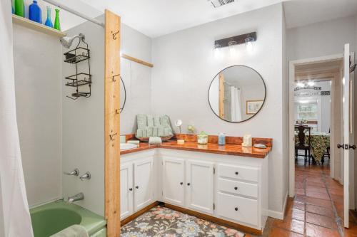 a bathroom with a tub and a sink and a mirror at Guadalupe Getaway in Kerrville