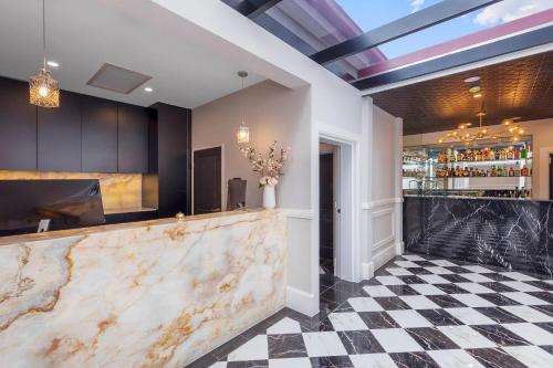 a bar with a marble counter and a checkered floor at Gladius Hotels & Suites Parramatta, an Ascend Hotel Collection in Parramatta