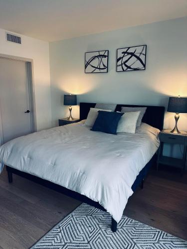 a bedroom with a large white bed with two lamps at Hollywood Luxury Retreat I Pool Views I Jacuzzi I Fitness Center I Free Parking! in Los Angeles