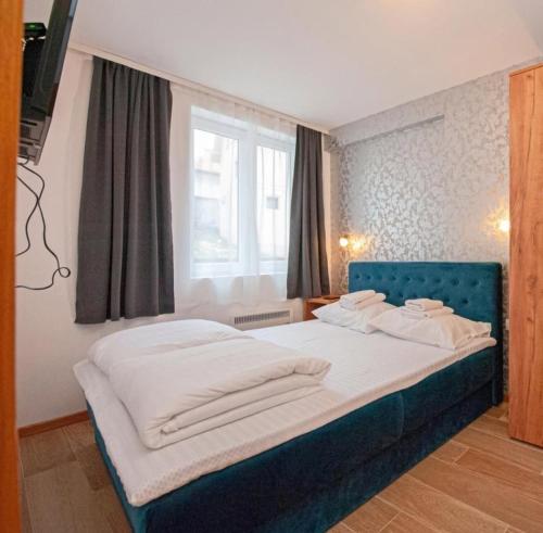 a bedroom with a bed with towels on it at Wolf Apartments Kopaonik in Kopaonik