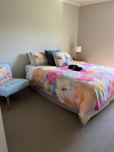 a bedroom with a bed with a colorful blanket and a chair at Portarlington Bayview in Portarlington