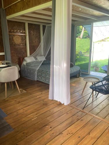 a room with a bed and a table and chairs at Eden des laves in Sainte-Rose
