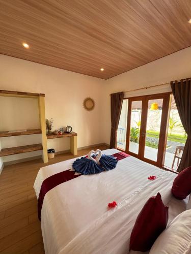 a bedroom with a large bed with red flowers on it at Lavanya Loka Balangan in Jimbaran