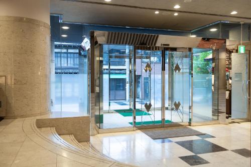 a lobby with glass doors in a building at HOTEL MYSTAYS Ueno East in Tokyo