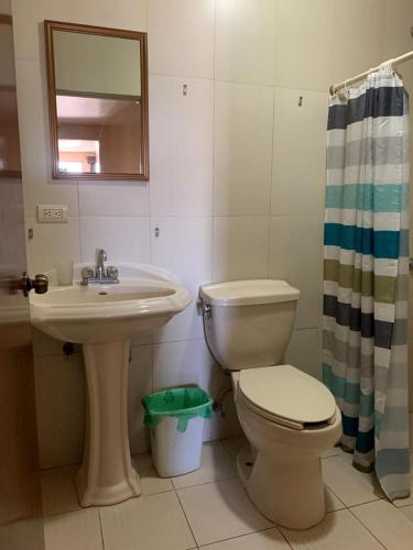 a bathroom with a toilet and a sink and a mirror at Suites Posada Obregon in Ciudad Obregón