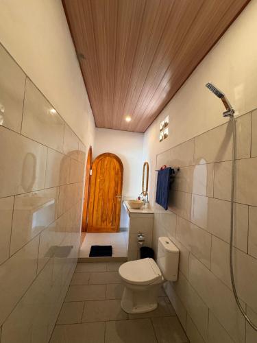 a bathroom with a toilet and a shower and a door at Lavanya Loka Balangan in Jimbaran