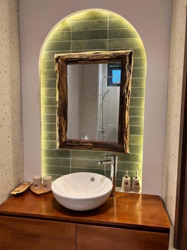 a bathroom with a sink and a mirror on a counter at Homestay Mộc An in Lagi
