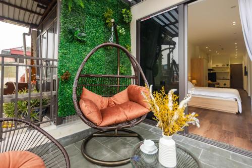 a swing chair on a balcony with a bedroom at Nesta Home - Old Street in Hanoi