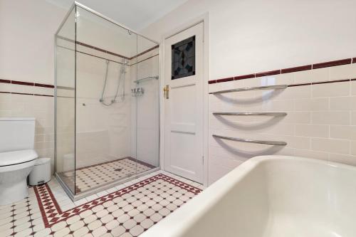 a bathroom with a shower and a tub and a toilet at Gated & Secure Single-Level Home in CBD in Turner
