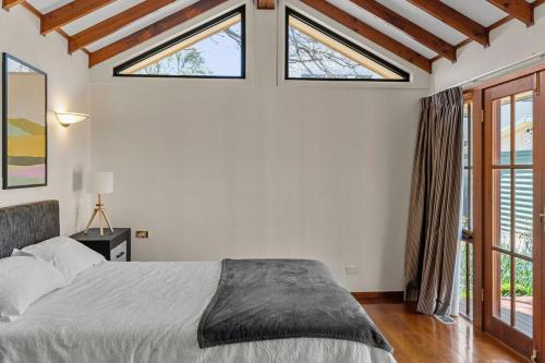 a bedroom with a bed and two windows at Gated & Secure Single-Level Home in CBD in Turner