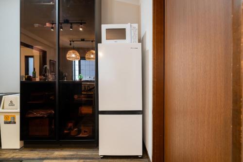 a white refrigerator with a microwave on top of it at HOTEL AndPlace ShinOkubo in Tokyo