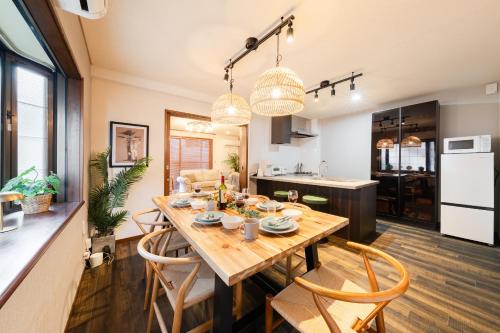 a kitchen and dining room with a wooden table and chairs at HOTEL AndPlace ShinOkubo in Tokyo