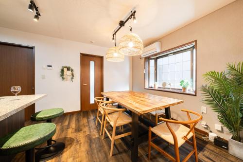 a dining room with a wooden table and chairs at HOTEL AndPlace ShinOkubo in Tokyo