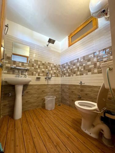 a bathroom with a sink and a toilet at Bir Nest Hostel in Bīr