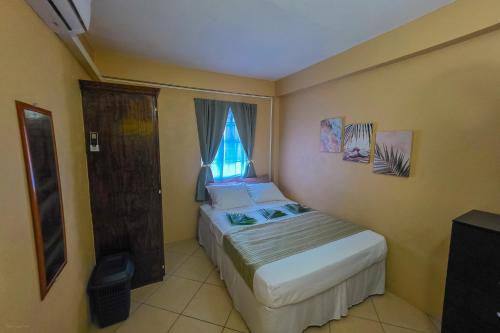 a small bedroom with a bed and a window at SK S Haven #1 in Castries