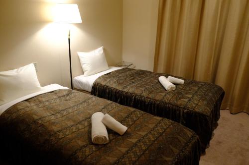 a hotel room with two beds with white pillows at Azumino World Curry House Spice Road in Matsukawa