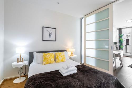 a bedroom with a large bed with yellow pillows at Comfortable Loft Living in Footscray in Melbourne