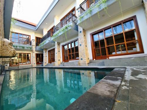 a house with a swimming pool in front of it at Kamandaka Living in Kuta
