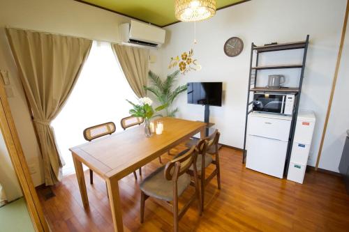 a dining room with a wooden table and chairs at カラハーイもとぶ 2-3 in Motobu