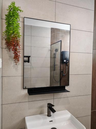 a mirror on a wall above a bathroom sink at White House in Malacca
