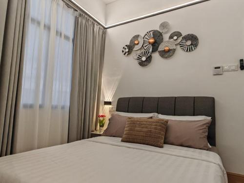 a bedroom with a bed with a clock on the wall at White House in Malacca