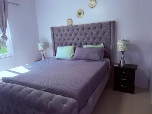 una camera da letto con un letto grande con una grande testiera di Jamrock Suites a Kingston
